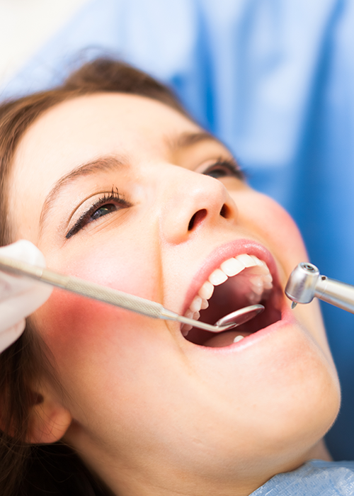 Dentist cleaning patient's teeth.